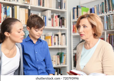 Young mother and little boy on meeting with teacher at school