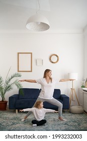 Young Mother With Little Daughter Practicing Yoga At Home. Family Fizical Activity, Sporty Mom And Kid