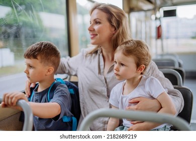 Young mother with little kids travelling in tram in summer, commuting and sustainable lifestyle concept.