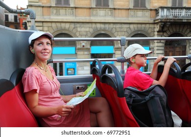 young mother and little son looking on street of Rome in tour bus in Rome, Italy, focus on mother