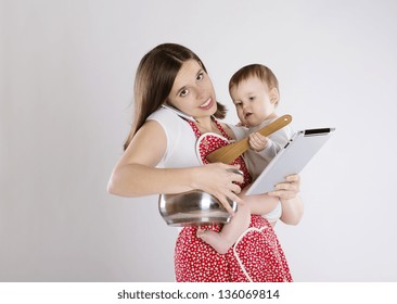 Young mother is looking at tablet with her baby