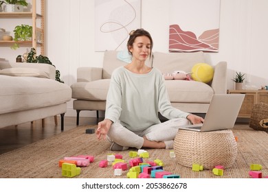 Young Mother Meditating On Floor In Messy Living Room