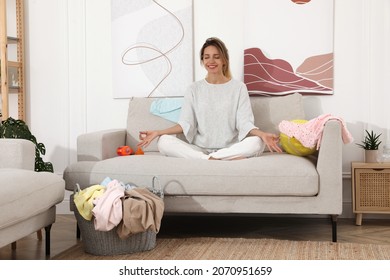 Young Mother Meditating On Sofa In Messy Living Room