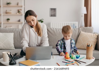 Young Mother Multitasking, Talking On Cellphone, Using Laptop And Taking Care Of Kid Son, Busy Mom Working Online While Babysitting Her Child At Home. Remote Job Opportunities