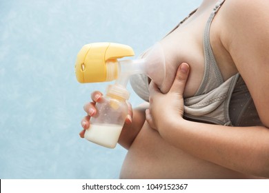 Young mother pumped breast milk. pump works on batteries, convenient to use. Breast milk for supplementary feeding, infant nutrition. feeding bra with detachable valves. Breast Pump in Female Hand.