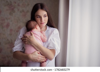 A Young Mother Rocks Her Kid And Sings A Lullaby At Home. A Restless Child Does Not Sleep. 