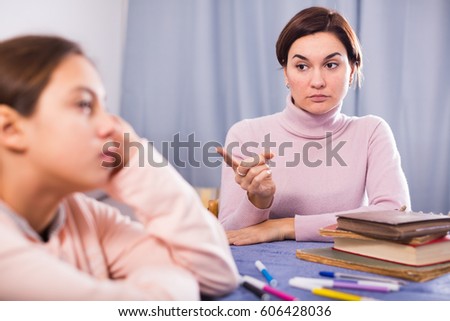 Young mother seriously talks to daughter about bad progress at school