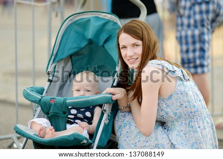 Young mother and a smiling baby in a stroller