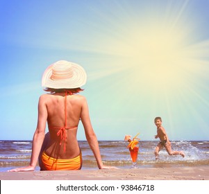 Young Mother With Son On The Beach