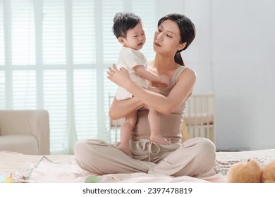 Young mother soothes crying baby - Powered by Shutterstock