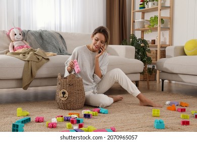 Young Mother Talking On Phone In Messy Living Room