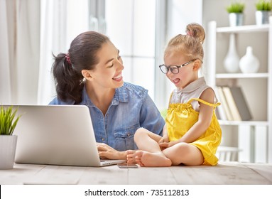 Young Mother With Toddler Child Working On The Computer From Home.