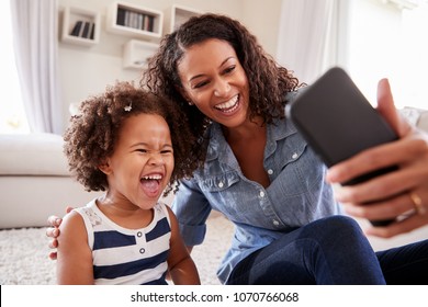 Young mother and toddler daughter taking selfie at home - Powered by Shutterstock