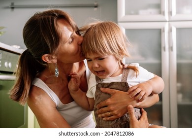 Young Mother Tries To Calm Her Crying Little Daughter. Raising  Child Concept.