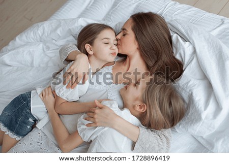 Similar – Little girl playing over boy lying in the bed