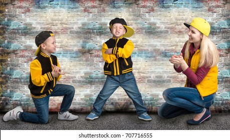  A Young Mother And Two Young Sons In The Style Of Hip Hop.Fashionable Family.Graffiti On The Walls.