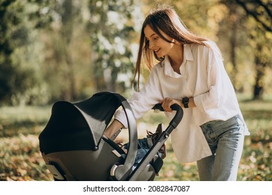 Young Mother Walking With Baby Stroller