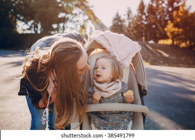 young mother walking with her baby and carries it in a beautiful pram