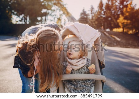 young mother walking with her baby and carries it in a beautiful pram
