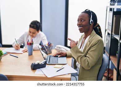 Young Mother Wearing Call Center Agent Headset Pointing Thumb Up To The Side Smiling Happy With Open Mouth 