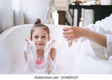 Young Mother Woman And Little Tween Girl Daughter Having Fun In The Bath With Foam At Home