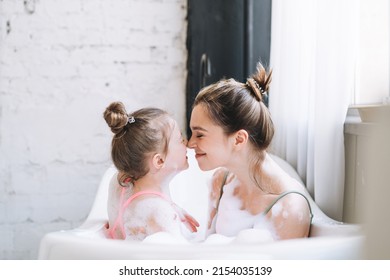 Young Mother Woman And Little Tween Girl Daughter Having Fun In Bath With Foam At Home