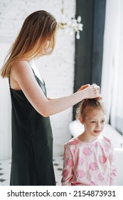 Young Mother Woman With Long Hair In Black Dress And Little Tween Girl Daughter In Pajamas Having Fun In The Morning At Home, Family Spending Time Together In Bathroom