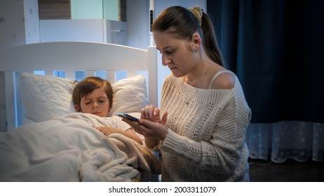 Young mother worrying about her sick son sleeping in bed calling doctor. Concept of children illness, disease and parent care - Powered by Shutterstock