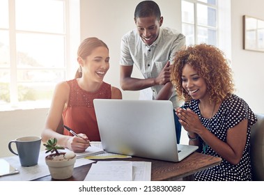 Young Movers And Shakers In Design. Shot Of A Group Of Colleagues Working Together On A Laptop In An Office.