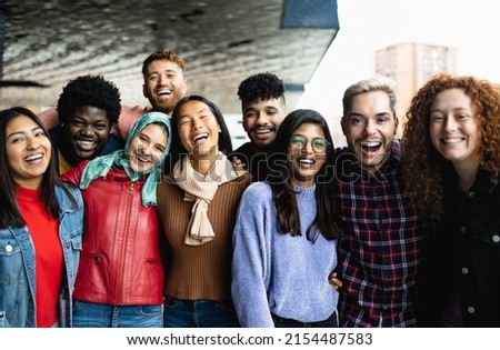 Young multi ethnic friends having fun together hanging out in the city - Friendship and diversity concept