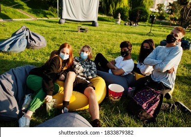 Young Multi Ethnic Group Of People Watching Movie At Poof In Open Air Cinema Wear At Mask During Covid Coronavirus Quarantine.