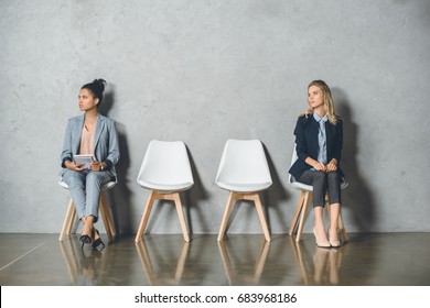 young multicultural businesswomen sitting on chairs and waiting for job interview - Shutterstock ID 683968186