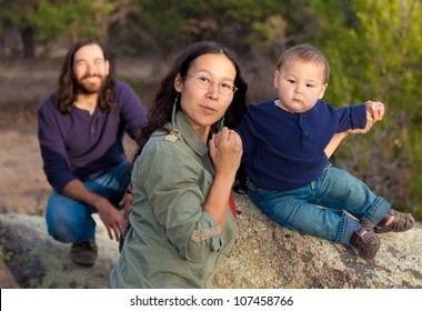 Young Multicultural Family In Nature - Shallow DOF - Focus On Mother & Baby