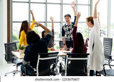 Young Multiethnic Diverse Creative Asian Group Huddle And High Five Hands Together In Office Workshop With Success Or Empower Expression In Teamwork. Young Asian Marketing Team With Copy Space.