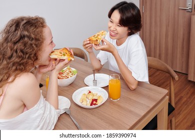 Young Multi-ethnic Lesbian Couple Eating Pizza For Dinner At Home