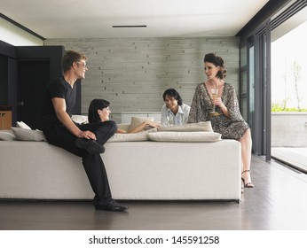 Young Multiethnic People Drinking Champagne In Villa Living Room