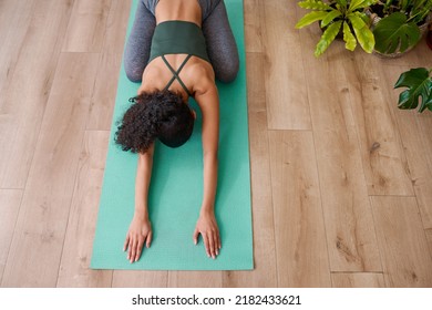 A Young Multi-ethnic Woman Rests In Child's Pose On Yoga Mat - Cropped Overhead