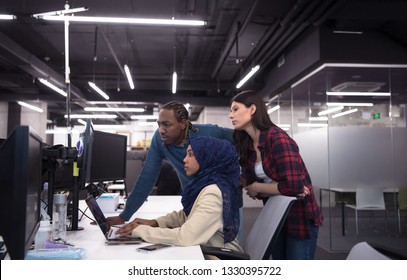 young multiethnics business team of software developers working together using laptop computer while writing programming code at modern startup office - Shutterstock ID 1330395722