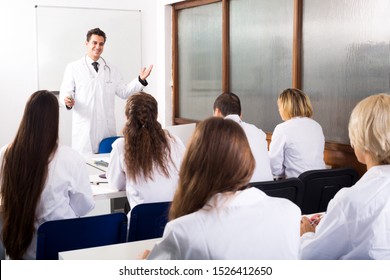 Young multinational interns and attractive professor having discussion at medical faculty
