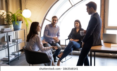 Young Multiracial Colleagues Friends Chatting Talking Discussing Work Company Policy On Informal Meeting, Diverse Millennial Managers Mates Have Conversation Sharing News Ideas At Break Time In Office