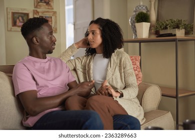 Young multiracial couple in deep conversation on their living room sofa - Powered by Shutterstock