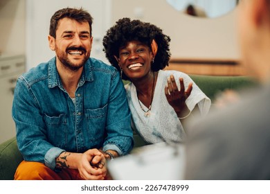 Young multiracial couple smiling because solved conflict at couple therapy session with a counseling adviser and. Diverse spouses being happy with a psychologist advises. Copy space. - Powered by Shutterstock