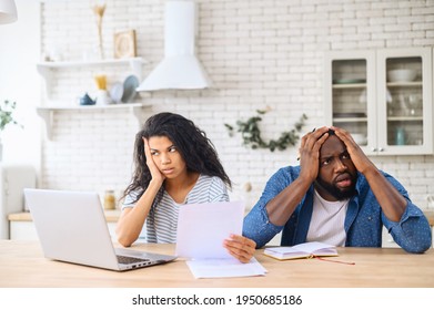Young multiracial family argued about their budget, stressful family couple have debt problems, not able to pay their loan, manage domestic budget, study paper documents, sitting in modern apartment