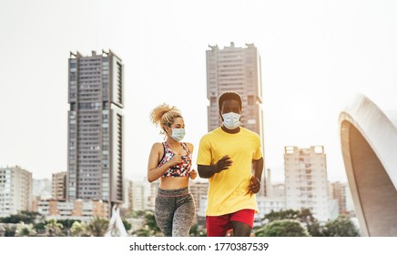 Young Multiracial Fit Friends Running Outdoor While Wearing Face Protective Masks During Coronavirus Outbreak - Fitness Lifestyle And Sport On Covid 19 Period - Main Focus On  Faces