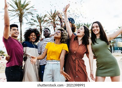 Young Multiracial Hipster People Having Fun In Summer Party Celebration - Group Of Young Friends Laughing And Celebrating All Together While Throwing Coloured Confetti At Weekend Event Outdoors