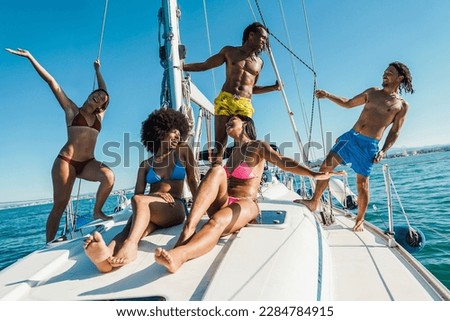 Young multiracial people having fun on sailing boat outdoor - Focus on center african girl face