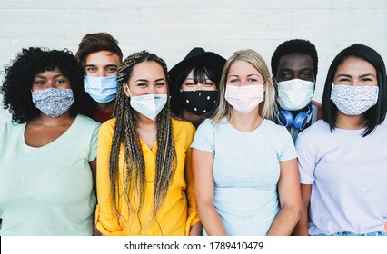 Young Multiracial People Wearing Protective Masks While Smiling In Camera - Happy Friends During Coronavirus Outbreak - Social Distance Concept - Main Focus On Girl With Yellow T-shirt Face