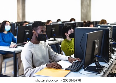 Young Multiracial Students Taking An Exam In High School While Wearing Face Mask During Corona Virus Pandemic - Education And Technology Concept