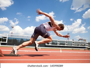 young muscular athlete is at the start of the treadmill at the stadium - Powered by Shutterstock