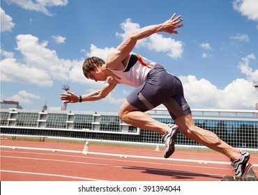 young muscular athlete is at the start of the treadmill at the stadium - Shutterstock ID 391394044